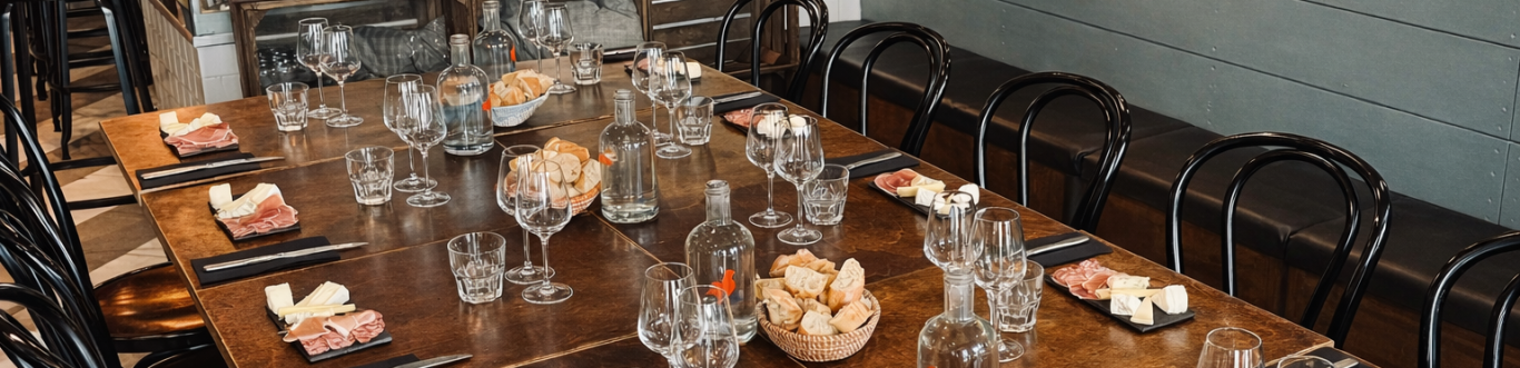 Wine tasting table set with glasses, artisan cheeses and charcuterie at ARCHIBON in Paris